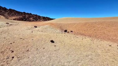 Nefes kesen bir çöl sahnesi eşsiz kaya oluşumlarını ve geniş kuru araziyi canlı bir gökyüzünün altında gösteriyor..