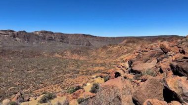 Kayalık çöl manzarasının nefes kesici manzarası açık mavi bir gökyüzü ve uçsuz bucaksız bir ufuk altında uzanır.