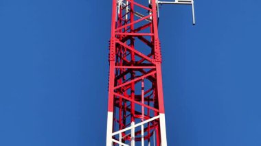 Çarpıcı bir iletişim kulesi, canlı mavi gökyüzüne karşı gelişmiş iletişim teknolojisi sergiliyor.