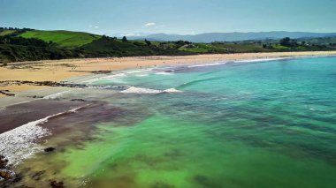 Göz kamaştırıcı hava manzarası, canlı mavi suları ve güzel manzaralarıyla sakin bir sahili yakalıyor.