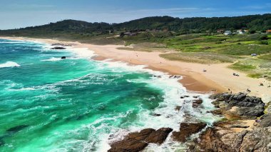 Bereketli yeşillik ve canlı turkuaz dalgalarla kaplı sakin bir plajı gösteren nefes kesici manzarayı izleyin.