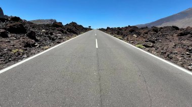 Güzel bir yol eşsiz volkanik arazide esiyor, nefes kesici manzaralar ve açık gökyüzü sunuyor.