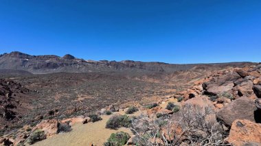 Engebeli kayalık çöl manzarasının nefes kesici ve geniş panoramik görüntüsü doğal güzelliğini vurgular.