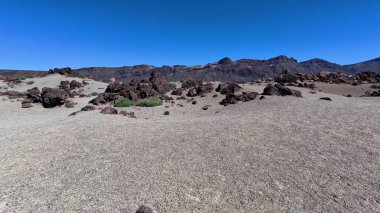 Çarpıcı kaya oluşumları, canlı renkler ve açık gökyüzü içeren dramatik çöl manzaralarını keşfedin ve keşfedin.