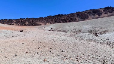 Uçsuz bucaksız, kurak bir çöl manzarasının nefes kesici ve çarpıcı manzarası. Parlak mavi gökyüzünün altındaki kayalık tepeler.
