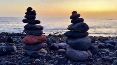 Güzel istiflenmiş taşlar, okyanusların kenarında günbatımında gerçekten huzurlu ve huzur verici bir sahne yaratıyor.