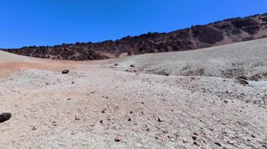 Uçsuz bucaksız, kurak bir çöl manzarasının nefes kesici ve çarpıcı manzarası. Parlak mavi gökyüzünün altındaki kayalık tepeler.