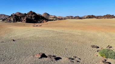Nefes kesici bir çöl sahnesi geniş kumlu arazide eşsiz kaya oluşumları sergiliyor.