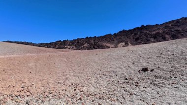 Uçsuz bucaksız ve nefes kesici bir çöl manzarası sergiliyor kayalık tepeleri sergiliyor hayret verici açık mavi gökyüzünün ortasında