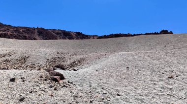 Uçsuz bucaksız, engebeli bir arazi parlak mavi gökyüzü tarafından aydınlatılmış, doğal temalı projeler için mükemmel.