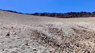 El değmemiş mavi gökyüzüne karşı kayalık bir manzaranın nefes kesici görüntüsü, saf güzelliği gözler önüne seriyor.