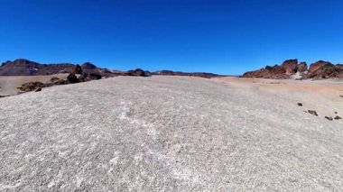 Uçsuz bucaksız çöl manzarası kayalık oluşumları ve pürüzsüz araziyi berrak mavi gökyüzünün altında güzel bir şekilde barındırır.