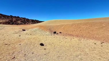 Berrak gökyüzünün altında canlı bir arazinin bulunduğu engin ve çorak bir arazinin nefes kesici ve çarpıcı manzarasının tadını çıkarın.