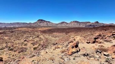 Göz kamaştırıcı bir panoramik manzara engebeli volkanik araziyi, berrak mavi gökyüzüne karşı güzelce zıt gösteriyor.