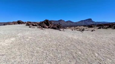 Engebeli bir arazinin nefes kesici ve dehşet verici manzarası kayalık oluşumlar ve canlı, renkli bir gökyüzü.