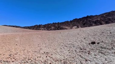 Uçsuz bucaksız ve nefes kesici bir çöl manzarası sergiliyor kayalık tepeleri sergiliyor hayret verici açık mavi gökyüzünün ortasında