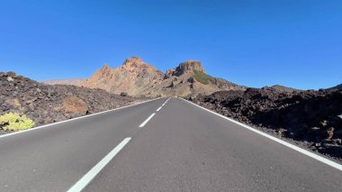 Güzel volkanik arazide ve görkemli dağlarda dolambaçlı bir yolun çarpıcı manzarasını tecrübe edin.