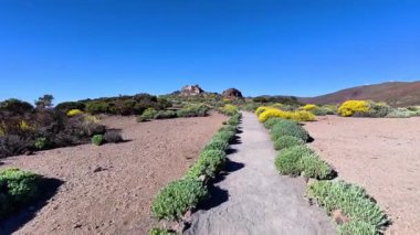 Canlı çiçeklerle bezenmiş nefes kesen güzel bir patika, insanı hayrete düşüren kurak bir manzaraya götürür.