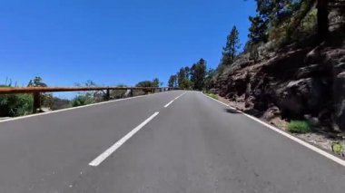 Etrafı çarpıcı yeşillik ve doğal güzelliklerle çevrili, dolambaçlı bir dağ yolunda güzel bir yolculuğun tadını çıkar.