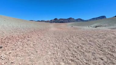 Kuru, kurumuş bir arazi engin mavi bir gökyüzünün altında uzanır, gerçekten çarpıcı kurak bir manzarayı sergiler.