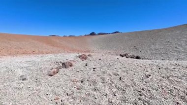 Eşsiz çöl arazisinin çarpıcı panoramik manzarası canlı renkler ve karmaşık dokular sergiliyor.