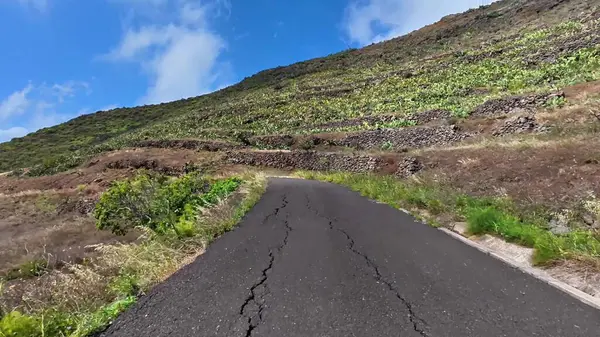 Sizi bereketli volkanik dağ manzaralarından geçiren dolambaçlı toprak bir yol boyunca manzaralı bir yolculuğa çıkın.