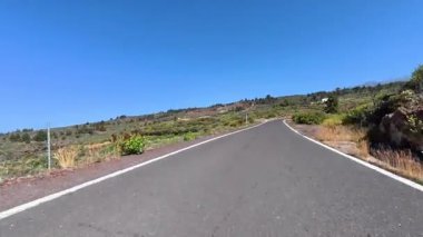 Güzel manzaralar ve canlı yeşilliklerle çevrili dolambaçlı yolda manzaralı bir yolculuğun tadını çıkar.