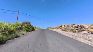 Güzel, pitoresk bir yokuş yukarı, canlı yemyeşil ve berrak mavi gökyüzü ile çevrili.