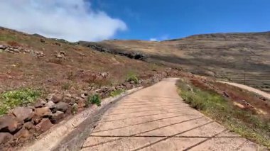 Berrak mavi gökyüzünün altındaki engebeli dağların arasından esen bu nefes kesici yolun değerini anlamak için bir dakikanızı ayırın.