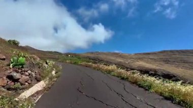 Güzel, dolambaçlı bir yol engebeli arazide dolaşır, doğanın çarpıcı güzelliğini ve huzurunu gözler önüne serer.