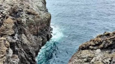 Heyecan verici bir macerada dalgaların kristal berrak sulara düştüğü çarpıcı kayalık kıyı şeridini keşfedin