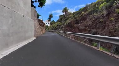 Bereketli yeşillik ve kayalık oluşumlarla çevrili güzel bir kıyı yolunun çarpıcı ve resimsel manzarası.