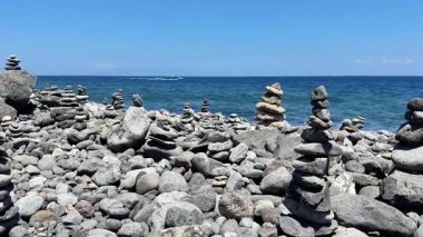 Huzurlu bir plaj sahnesi güzel istiflenmiş taş cairns kayalık bir kıyı şeridi boyunca konumlandırılmış