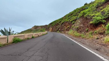 Sersemletici derecede güzel, dolambaçlı bir yol, bulutlu bir günde yemyeşil bir dağ zeminine güzel bir şekilde kurulmuş.
