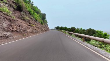 Çevresindeki doğa tarafından mükemmel çerçevelenmiş güzel, dolambaçlı bir yol, seyahat ve keşif maceraları için ideal.