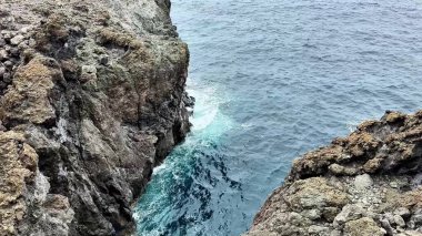 Heyecan verici bir macerada dalgaların kristal berrak sulara düştüğü çarpıcı kayalık kıyı şeridini keşfedin