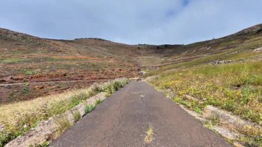 Bereketli yeşillik ve engebeli araziyle çevrili huzurlu bir dağ yolunda keyifli bir yolculuğa çıkın.