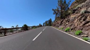 Canlı çiçekler ve açık mavi gökyüzü ile süslenmiş nefes kesici bir dağ yolunda heyecanlı bir yolculuğa çıkın.