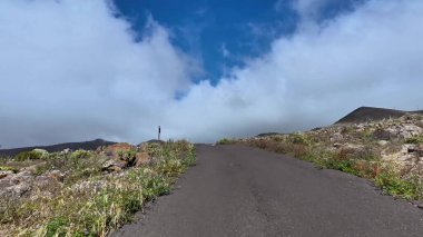 Resimli bir yol heybetli bir dağa döner, göz kamaştırıcı manzaralar ve parlak mavi gökyüzü