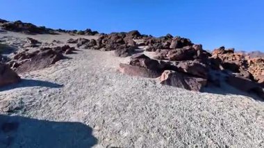 Uçsuz bucaksız bir çöl arazisinde eşsiz kaya oluşumları arasında dolaşan kayalık bir yolun nefes kesici sakin bir görüntüsü.