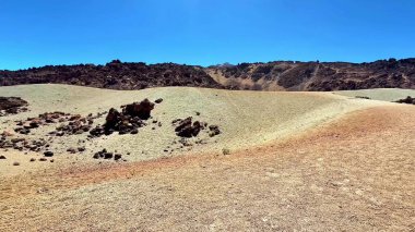 Ayrı tepeler, kayalar ve berrak mavi gökyüzünün sükuneti davet ettiği büyüleyici, çorak bir araziyi keşfedin.