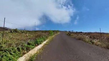 Huzurlu bir kır yolunda sakin bir gezinti yapın. Bu yolda resim gibi manzaralar ve büyüleyici bulutlar vardır.