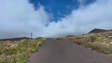 Resimli bir yol heybetli bir dağa döner, göz kamaştırıcı manzaralar ve parlak mavi gökyüzü