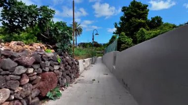 Bereketli yeşil ve büyüleyici taş duvarların arasında, bulutlu, parlak gökyüzünün altında huzurlu bir yolda yürü.