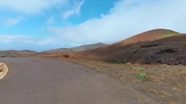 Yol kenarından, canlı renkleri ve açık mavi gökyüzü olan volkanik tepelerin güzel manzarasının tadını çıkarın.