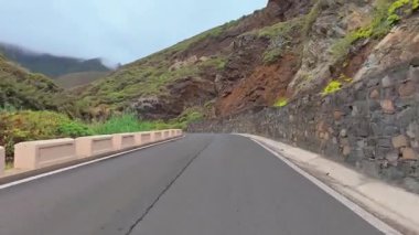 Çarpıcı dağlık arazilerde gezinen dolambaçlı bir yolun nefes kesici ve resimsel bir görüntüsü.