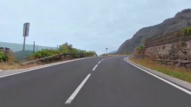 Göz kamaştırıcı doğal manzaralar ve manzaralarla çevrili manzaralı bir dağ yolu boyunca bir yolculuğa çıkın.