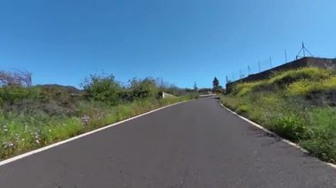 Dönek bir yol canlı bir yeşilliğin içinden geçiyor ve açık gökyüzünün altında, tüm doğa aşıkları için mükemmel.