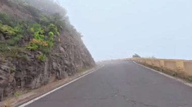 Bereketli yeşillik ve yüksek kayalıklar tarafından çerçevelenmiş, sisle kaplanmış çarpıcı manzaralı bir yolda yolculuğa çıkın.