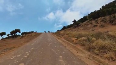 Doğayla çevrili dolambaçlı bir dağ yolunun huzur verici, nefes kesici güzelliğini keşfedin ve keşfedin.